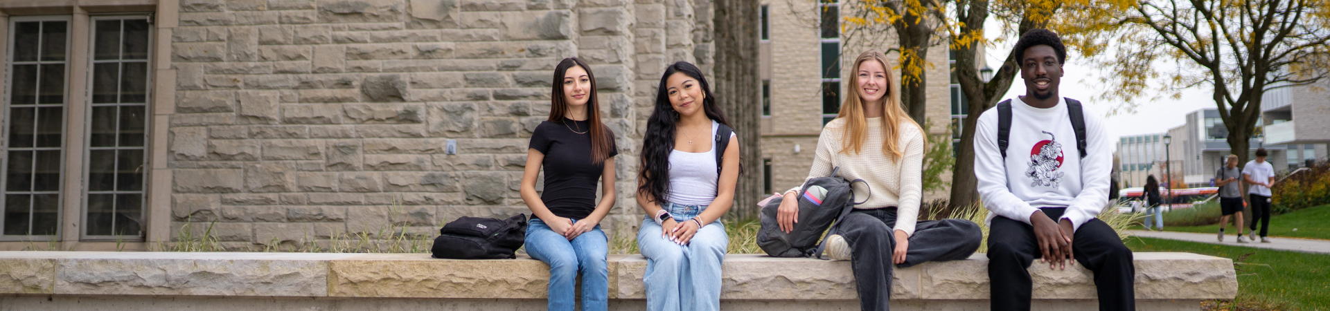 a group of students walking outside of University College on a fall day.