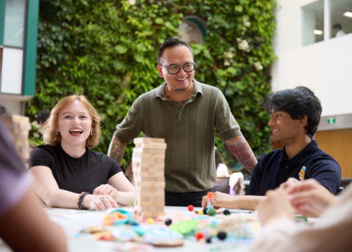 Students sitting at a table, smiling and working together.