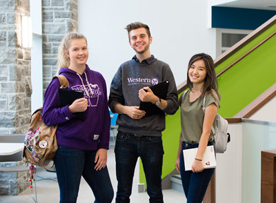 Three students smile at the camera